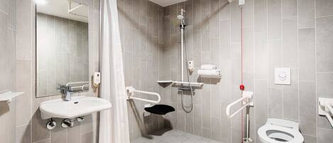 A modern bathroom with a shower, toilet, and sink.
