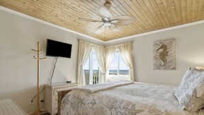 A bedroom with a bed, a flat-screen TV, a coat rack, and a window with curtains. - LABOR DAY 2 NGT MINIMUM  SPECIAL! GORGEOUS CONDO WITH BEAUTIFUL OCEAN VIEWS! (Atlantic Beach)
