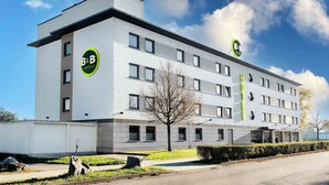 A modern B&B hotel with a flat facade, multiple windows, and a clear sky. - B&B Hotel Baden-Airpark (Rheinmunster)