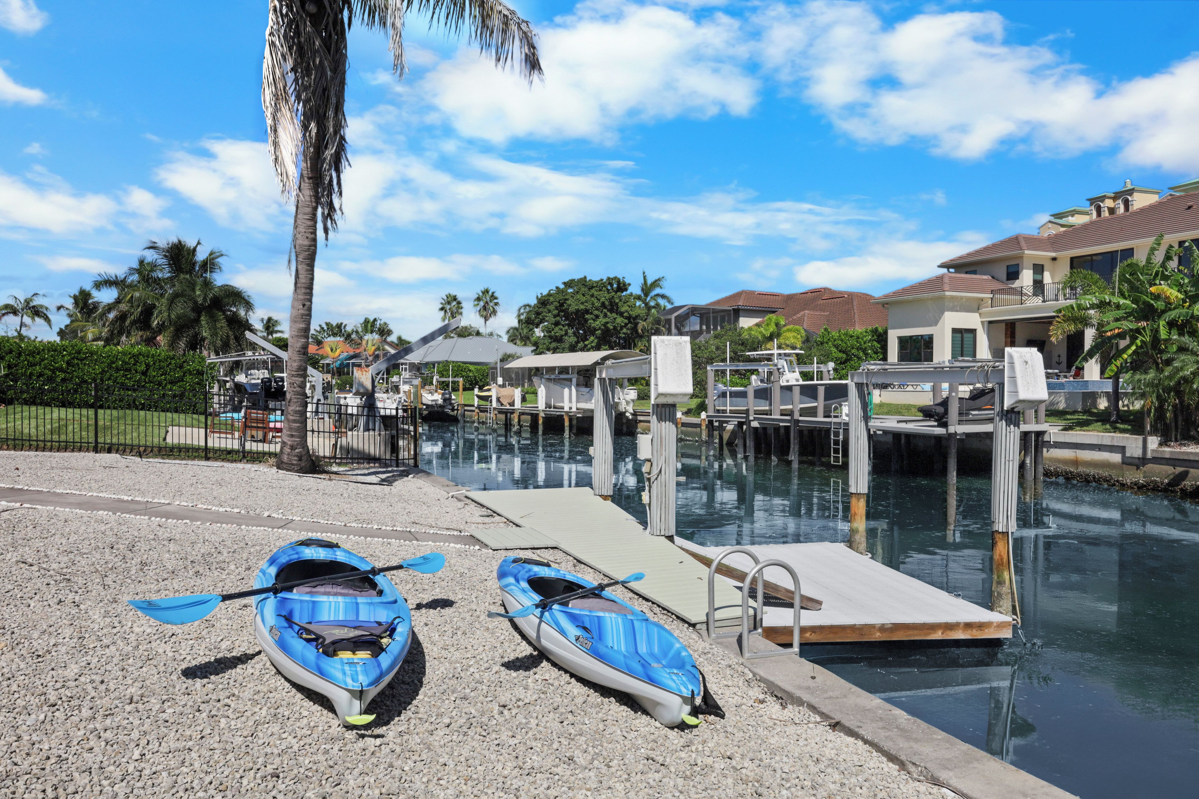 Un port de plaisance avec des kayaks amarrés, une jetée et un ciel dégagé.
