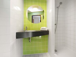 Een badkamer met een zwart aanrechtwastafel, een spiegel erboven en een douche aan de rechterkant.