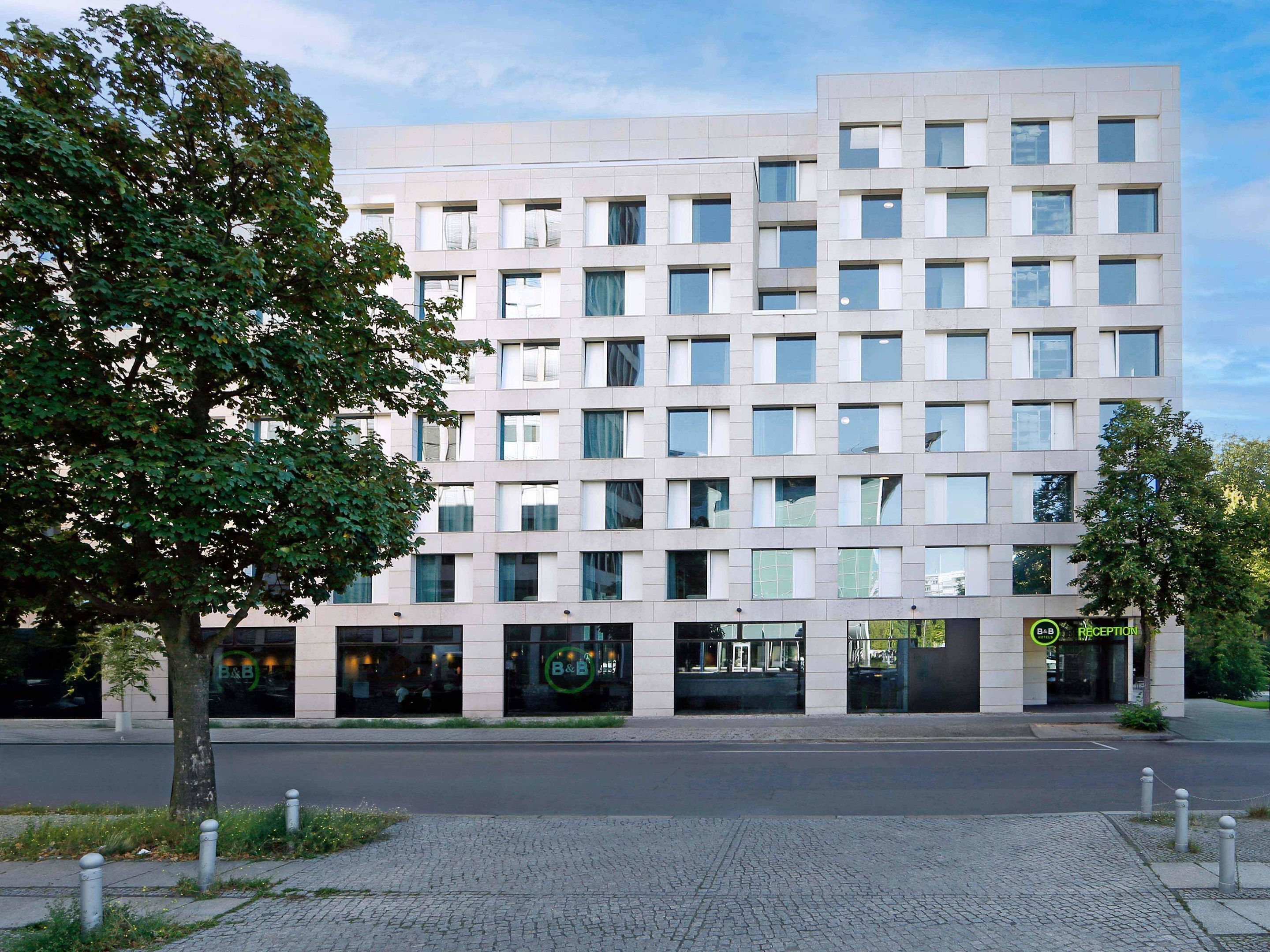 A modern multi-story building with a flat facade, large windows, and a reception area.