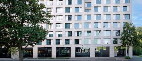 A modern multi-story building with a flat facade, large windows, and a reception area.