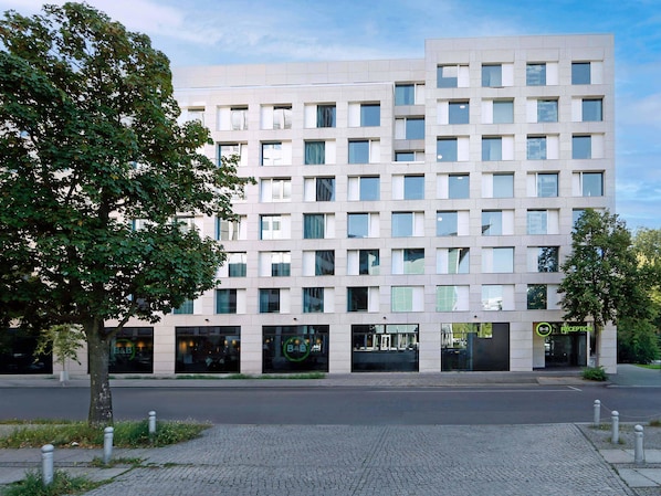 Un immeuble moderne à plusieurs étages, doté d’une façade sobre, de grandes fenêtres et d’un espace d’accueil.