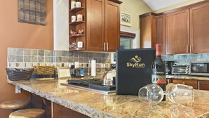 A kitchen with granite countertops, wooden cabinets, a black refrigerator, and a microwave. - Brekke's Basecamp 3 Bedroom Home by RedAwning (Park City)