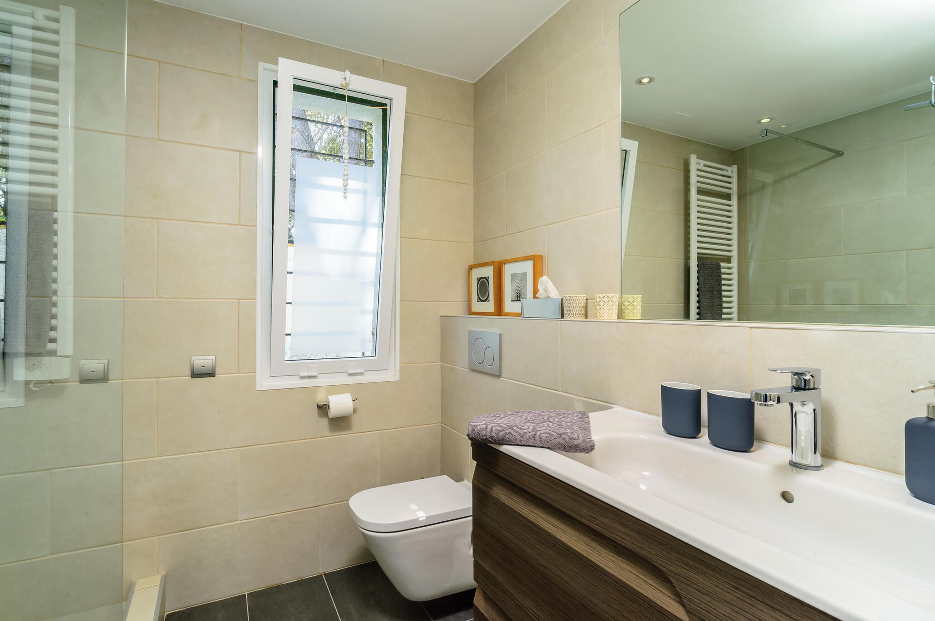 Une salle de bain moderne avec des toilettes, un lavabo et un grand miroir.