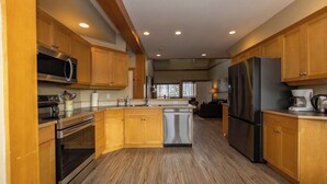 A modern kitchen with wooden cabinets, stainless steel appliances, and a central island.