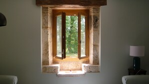 A room with a small window, a lamp, and two chairs. - Luxury gite for adult couples, peaceful, open views, large swimming pool (Boisse)