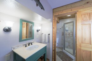 Un bagno con lavandino, specchio e doccia.
