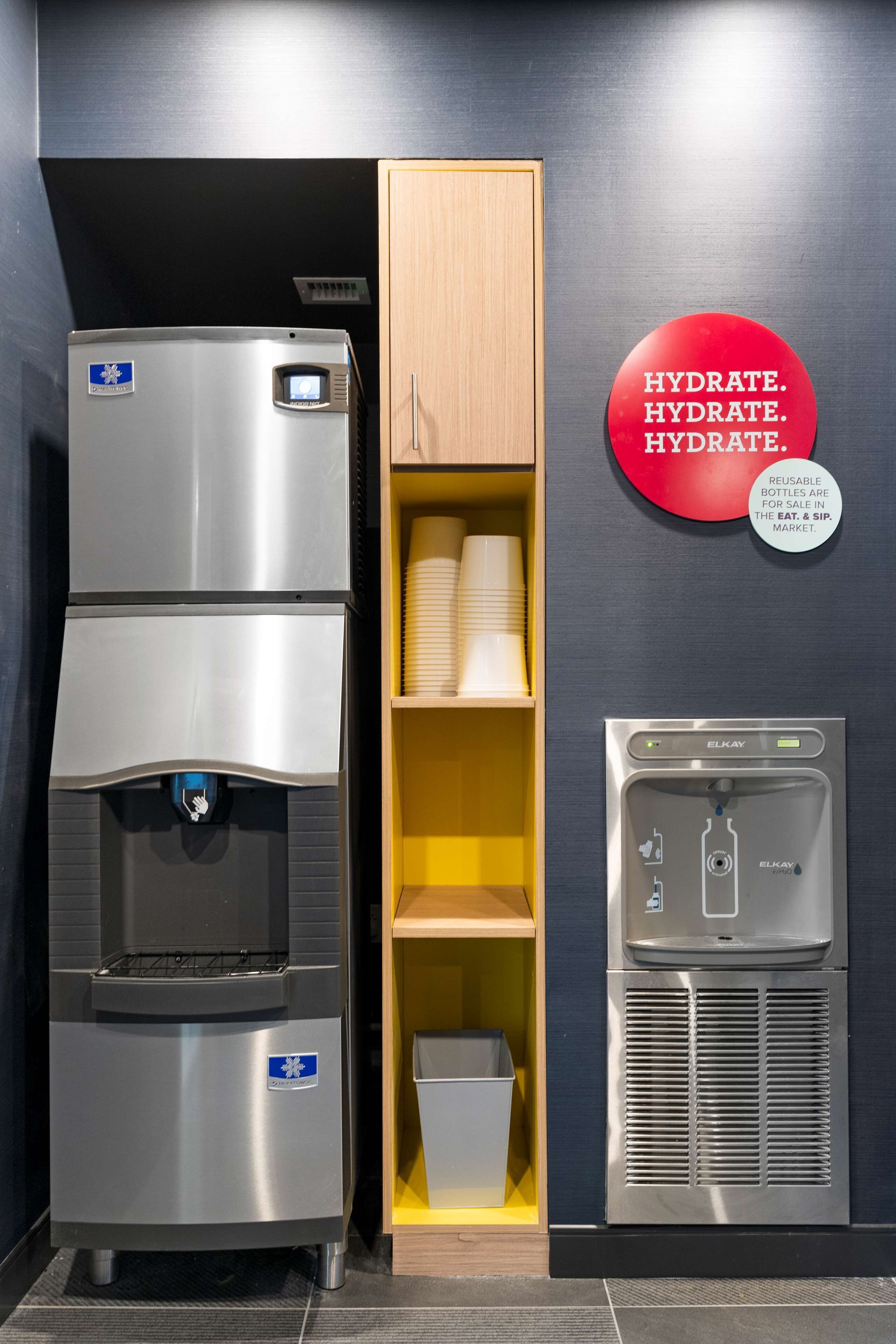 Un dispensador de agua y un refrigerador en un entorno comercial.