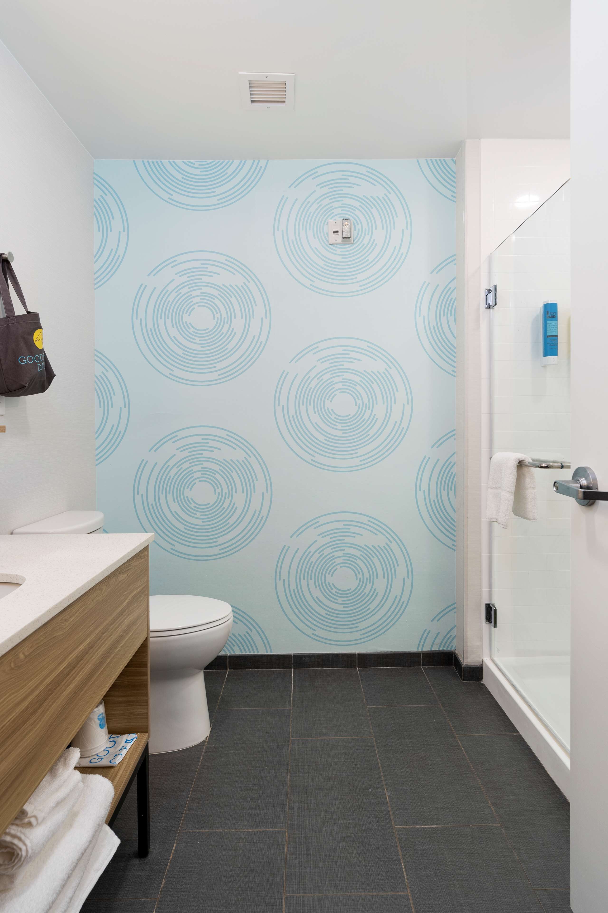 A bathroom with a toilet, a sink, a towel rack, and a shower area.