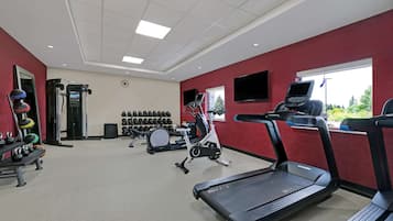 A gym with treadmills, an elliptical, and free weights.