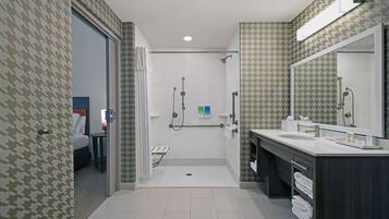 A modern bathroom with a shower, a sink, and a mirror.