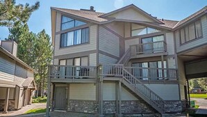 A multi-story residential building with a balcony, a staircase, and a garage.