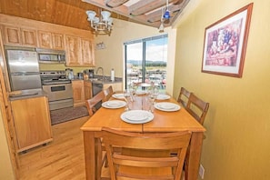 Enjoy meals at the dining table, surrounded by a view of the parking area and distant landscape.