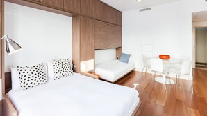 Habitació d'hotel moderna amb un llit gran, una taula de treball i una cadira.