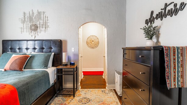Une chambre à coucher avec un lit, une commode et des éléments de décoration murale.