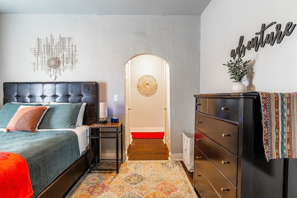 Une chambre à coucher avec un lit, une commode et des éléments de décoration murale.