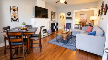 A living room with a sofa, a coffee table, a TV, and a fireplace.