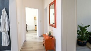 A hallway with a wooden dresser, a mirror, and a potted plant. - *NEW* Central (5min to city center) *Netflix & Amazon Prime* Kleiststrasse 4 MD (Sachsen-Anhalt - Magdeburg)