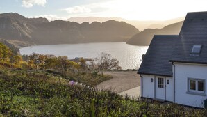 Una casa sul mare con vista sul mare e sulle montagne.