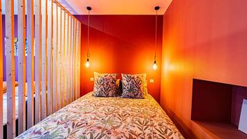 A bedroom with a bed, two pillows, and a wooden partition.