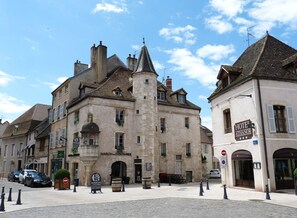 Un edificio histórico con una torre central, un letrero que dice 'MAISON DU COLOMBIER' y un letrero que dice 'HOTEL ATHANOR'.