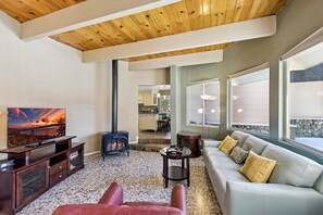 Ein modernes Wohnzimmer mit Kamin, Fernseher und Sofa.