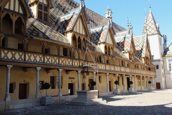 A historic building with a symmetrical facade, multiple gabled roofs, and a central courtyard.