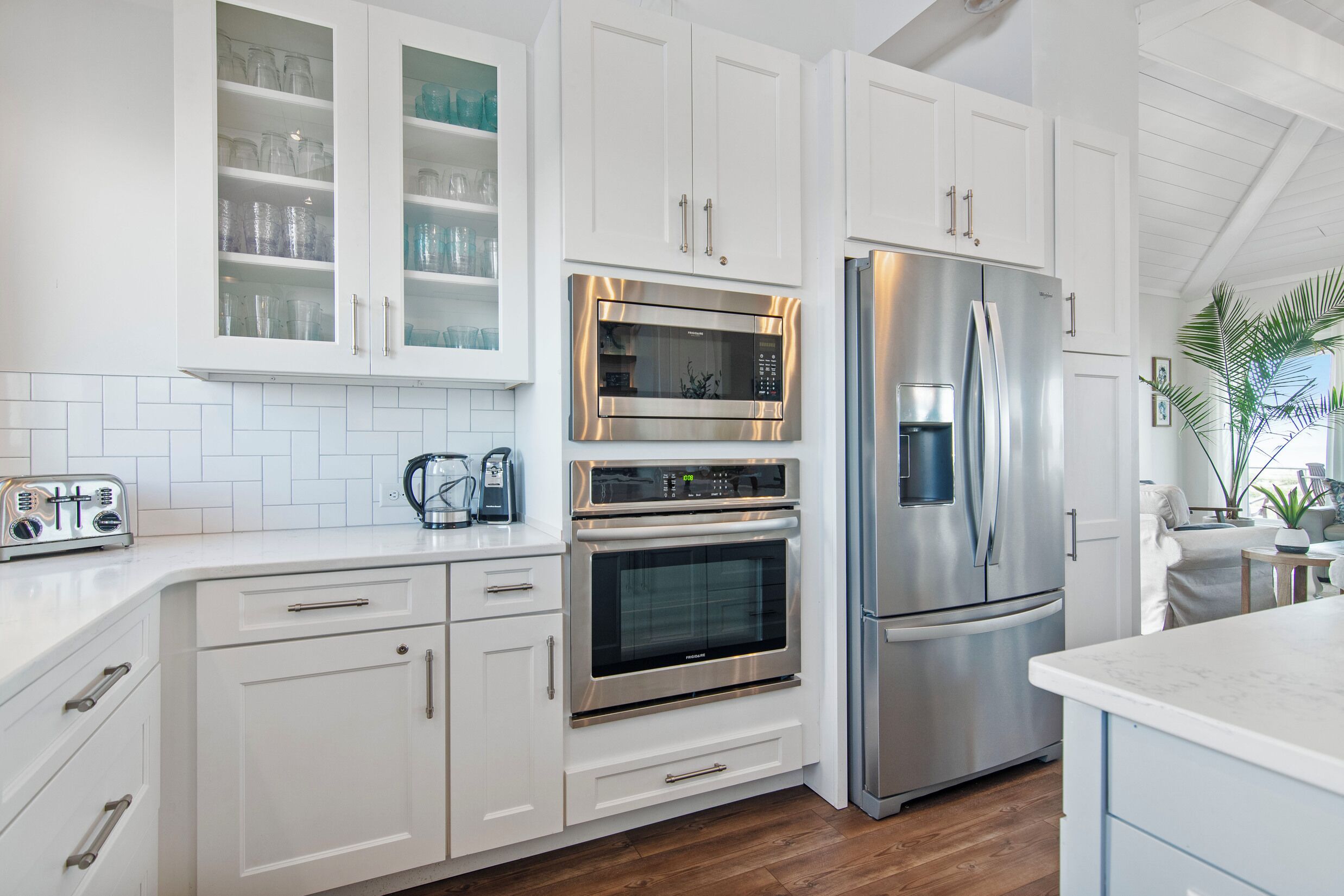 Una cocina moderna con armarios blancos, electrodomésticos de acero inoxidable y un salpicadero de azulejos.