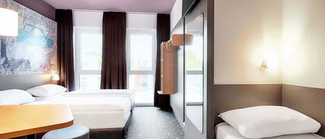 Une chambre d’hôtel avec deux lits, un bureau et une grande fenêtre avec des rideaux.