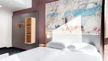Ein Hotelzimmer mit Bett, einer Holzregaleinheit und einem großen Wandposter mit einem blauen Auto und Gebäuden.