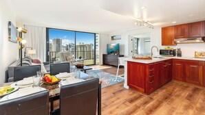 Un apartamento moderno con zona de comedor, cocina y ventanas amplias con vistas a la ciudad.