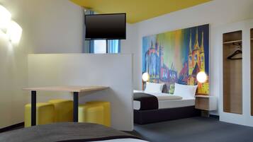 Una habitación de hotel moderna con una cama, un escritorio y una pintura de una catedral.