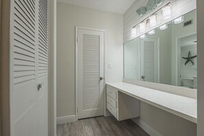 Een badkamer met een wit wastafelmeubel, een grote spiegel en een zeester decoratie.
