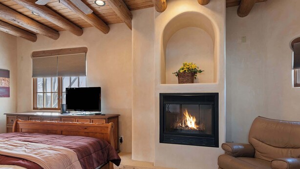 A bedroom with a bed, a TV, a fireplace, and a sofa. - Comfortable Family Home, Walk to The Plaza (Santa Fe)