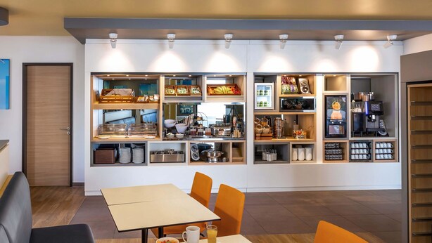 Un comedor moderno con una barra de buffet, que incluye diferentes tipos de comida y una máquina de café.