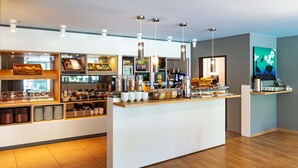 Eine moderne Frühstückstafel mit verschiedenen Speisen und einer Kaffeemaschine.