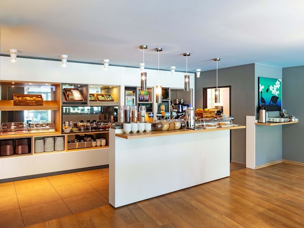 Una barra de desayuno moderna con diversos alimentos y una máquina de café.