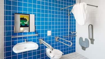 Un baño con azulejos azules, un lavabo, un inodoro y una zona de ducha.