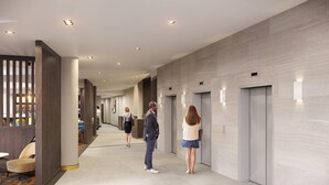 A modern hotel lobby with a long corridor, elevators, and seating areas. - Maldron Hotel Glasgow City (Glasgow)