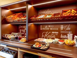 Ein Bereich mit Buffet und verschiedenen Speisen, sowie eine Wand mit motivierenden Zitaten.