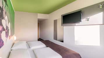 Ein Hotelzimmer mit einem Bett, einem an der Wand montierten Fernseher und einem Fenster.