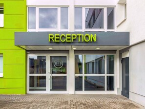 Un espace d’accueil avec une enseigne indiquant « RÉCEPTION » et le logo d’un établissement proposant des chambres d’hôtes.