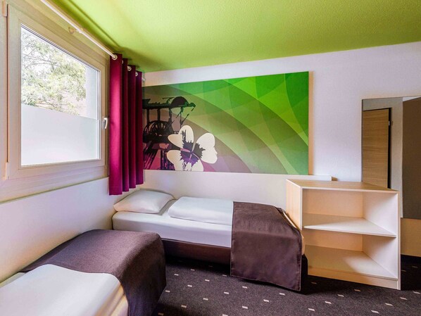 Una habitación pequeña y moderna con cama, escritorio y ventana con cortinas.