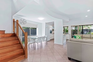 Enjoy a spacious living area with a sofa and dining space, featuring a glass table and chairs.