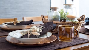 A dining table set with plates, bowls, a mug, and a basket. - Mita Guest House (Tokyo)