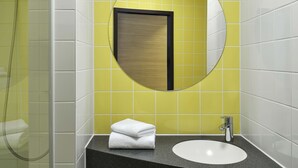 A bathroom with a round mirror, a sink, and a shower. - B&B HOTEL Halle (Saale) (Halle (Saale))
