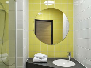 Un baño con un espejo redondo, un lavabo y una ducha.