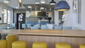 A modern restaurant interior with a bar area, seating arrangements, and decorative elements like orchids. - B&B HOTEL Halle (Saale) (Halle (Saale))